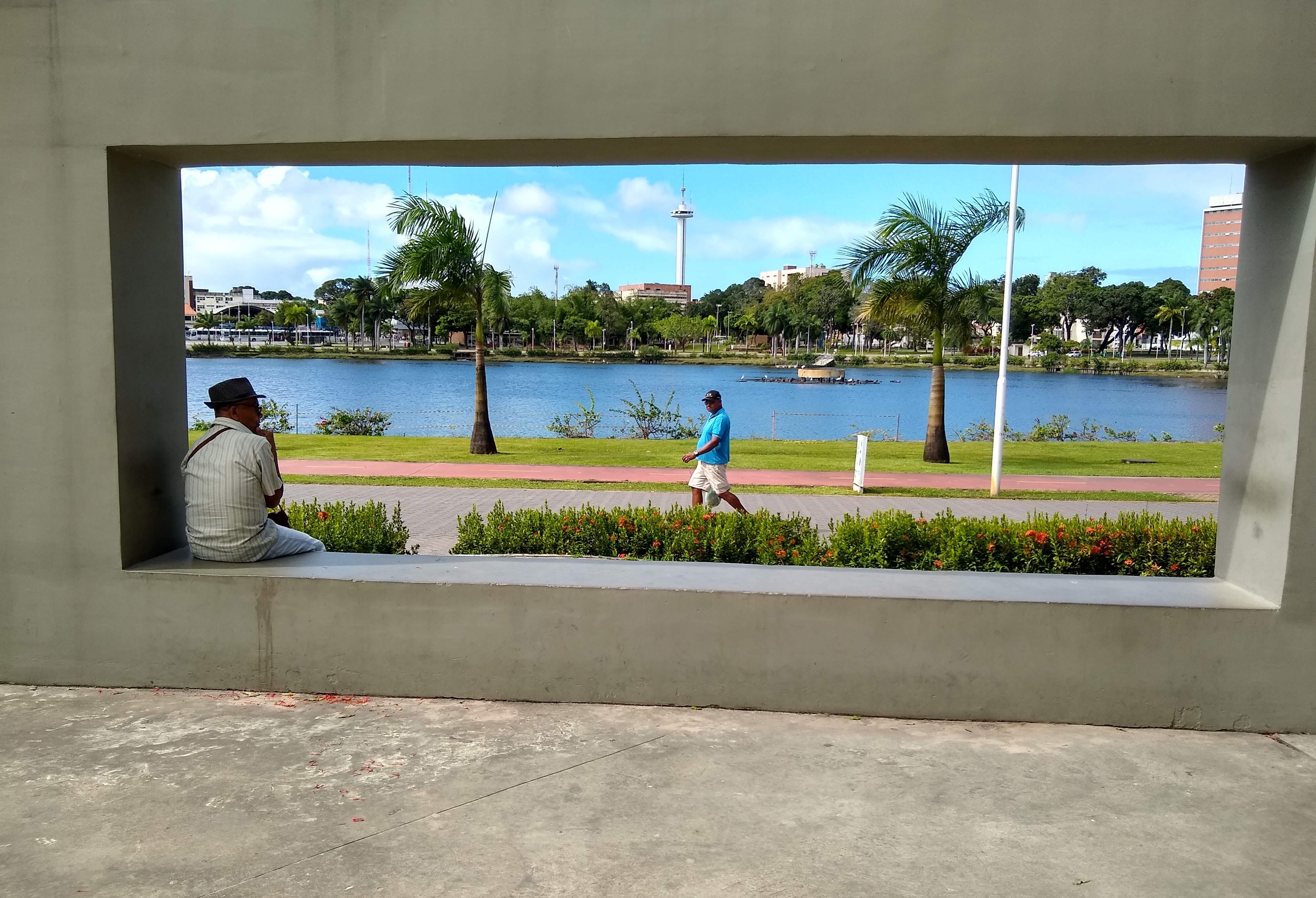 O ano era 2019. Eu tirava fotos espontâneas do Parque da Lagoa, quando me deparei com esse senhor sentado, perdido em pensamentos e contemplando a tudo e a todos. Chamou- a atenção o fato de parecer que ele estava dentro de um quadro, fazendo parte em primeiro plano da composição daquela “pintura.”