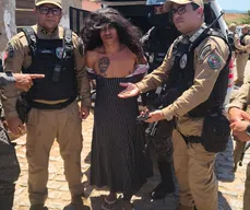 Homem suspeito de homicídios é preso vestido de mulher e segurando criança, em Mulungu