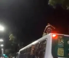 Homem é visto em cima de ônibus em movimento, em João Pessoa